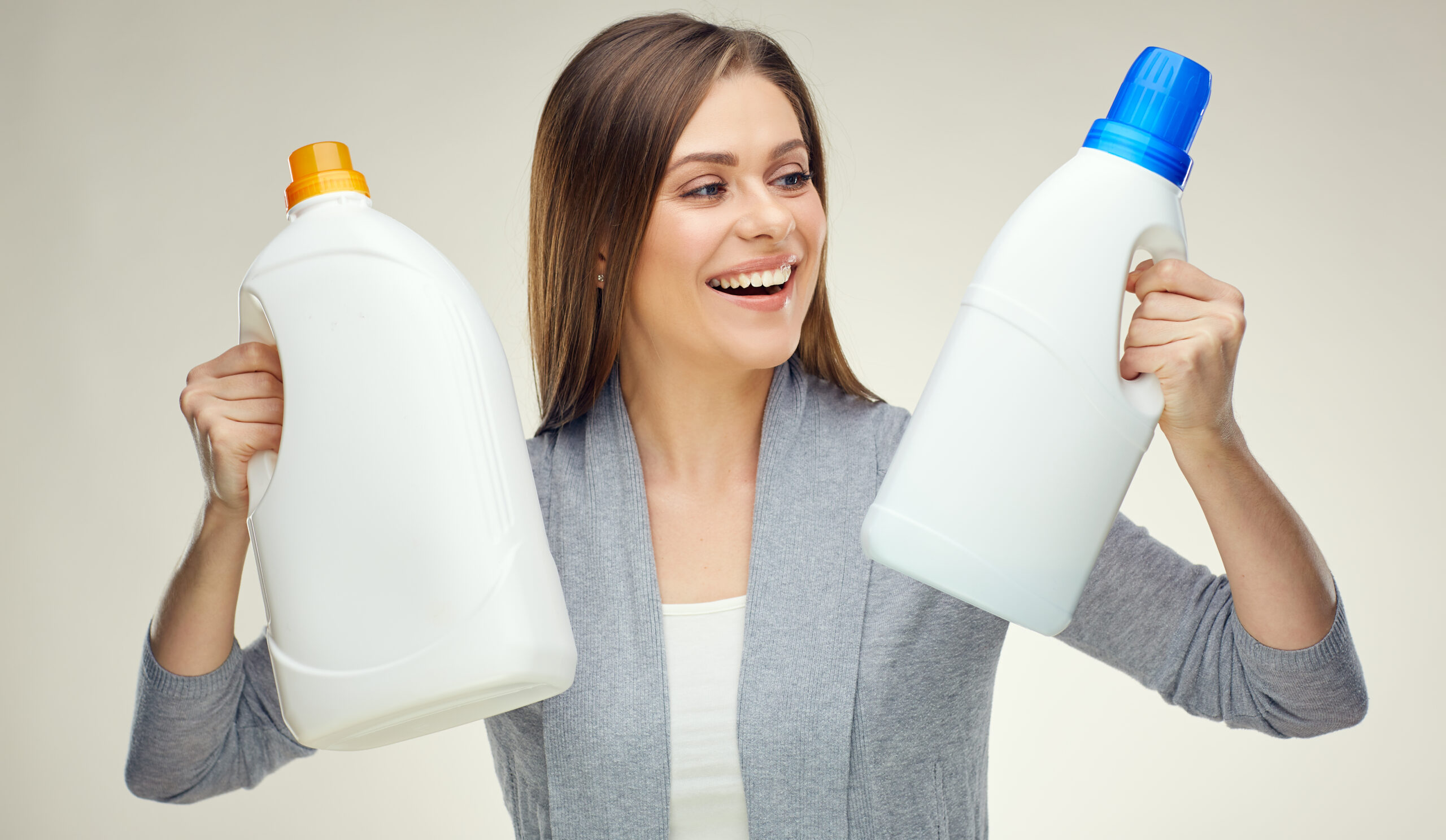 Woman,Compares,Two,Detergent,Bottle.,Isolated,Studio,Portrait,On,White.